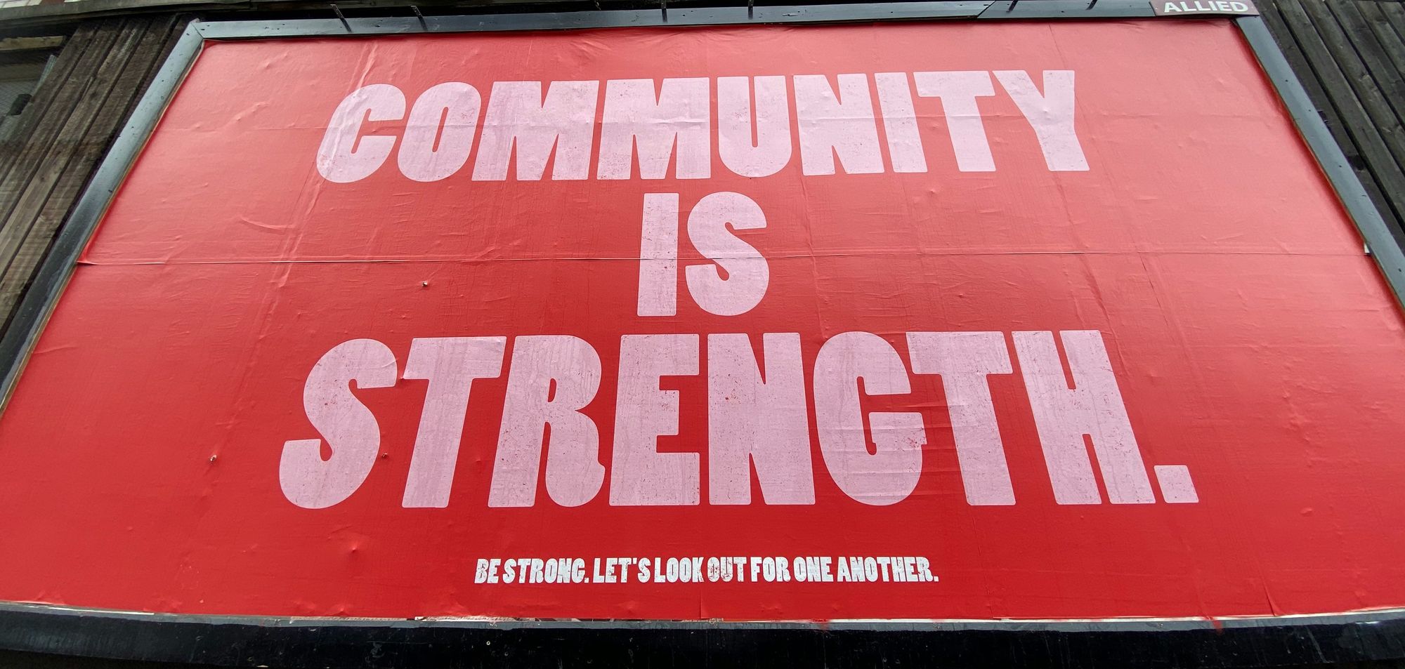 A red billboard that says 'Community is strength'